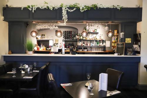 a restaurant with two tables and a bar at Ardennan House Hotel in Inverurie