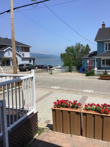 un balcón con flores en cajas en una calle en Petit Hôtel Amara en La Malbaie