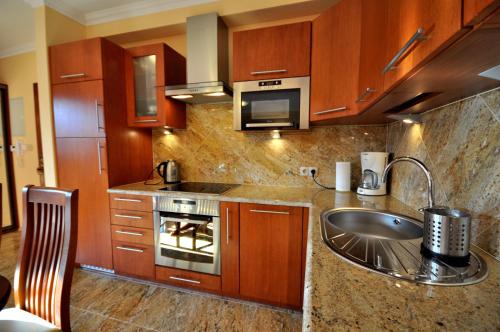 a kitchen with a sink and a stove top oven at Apartament Plumeria in Zakopane