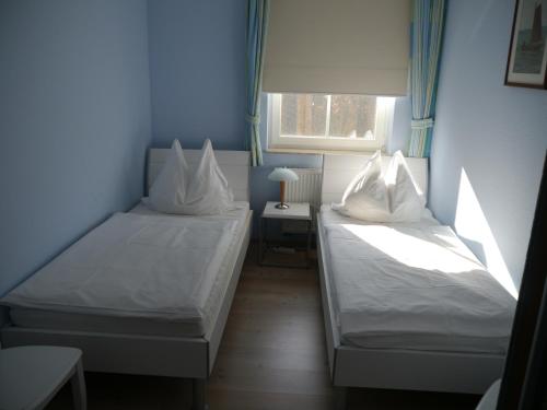 two beds in a small room with a window at Sünnenkringel 68 Appartement 1 in Zingst