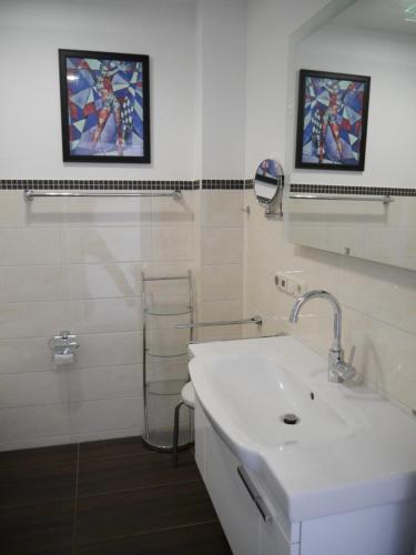 Baño blanco con lavabo y espejo en Sünnenkringel 68 Appartement 1 en Zingst