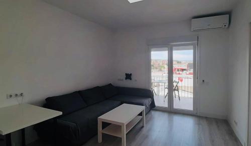 een woonkamer met een bank en een tafel bij White Apartment in Lloret de Mar