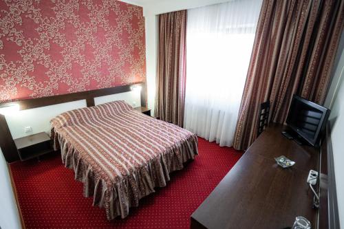 a hotel room with a bed and a television at Hotel Polaris in Suceava