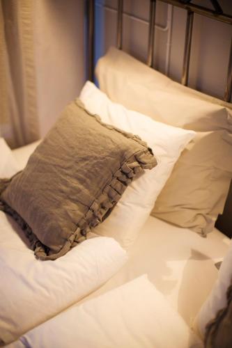 a pillow sitting on a bed with white pillows at Grand Hotell Hörnan in Uppsala