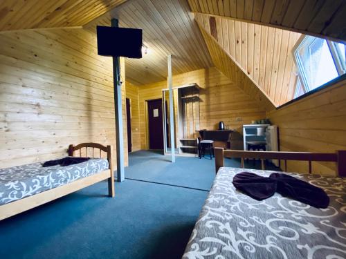 a bedroom with two beds in a wooden cabin at Русалка in Szack