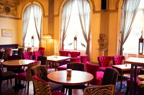 un restaurant avec des tables, des chaises et des fenêtres dans l'établissement Grand Hotell Hörnan, à Uppsala