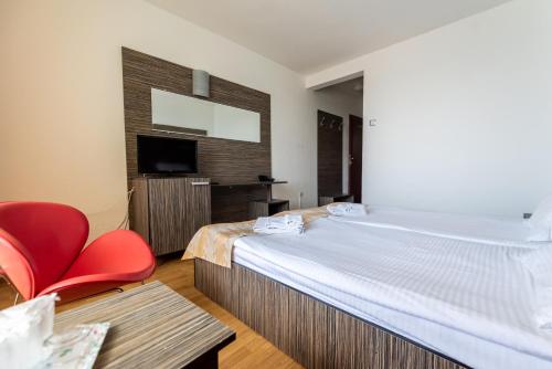 a hotel room with a large bed and a red chair at Hotel Capitol in Jupiter
