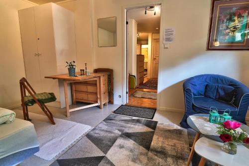 a living room with a blue chair and a table at Nora Gård in Åndalsnes