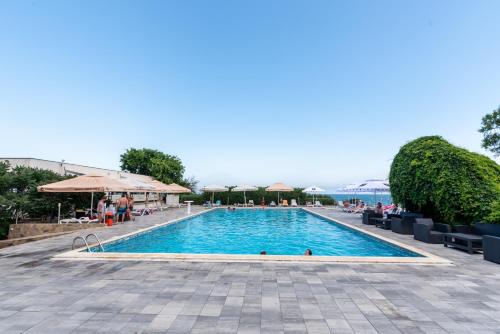 a large swimming pool with people sitting around it at Hotel Capitol in Jupiter