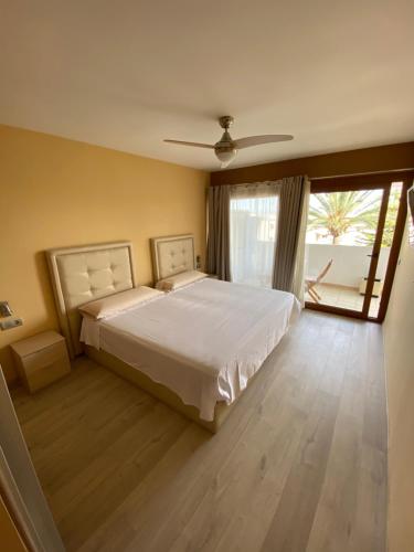 um quarto com uma cama grande e uma janela grande em Apartamento Vista Mar 410 em Port d'Alcudia