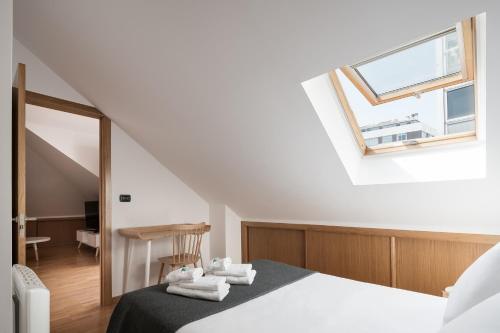 ein Schlafzimmer mit einem Bett mit Handtüchern darauf in der Unterkunft Atico en Santa Catalina in A Coruña