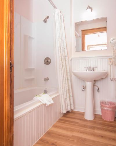 a white bathroom with a sink and a bath tub and a sink at Terrace Inn and 1911 Restaurant in Petoskey