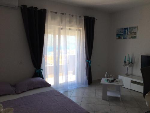 sypialnia z łóżkiem i dużym oknem w obiekcie Gavran Apartment Vinjerac w mieście Vinjerac