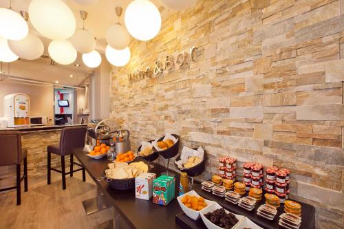 een buffet in een restaurant met een stenen muur bij Hôtel Eden Opéra in Parijs