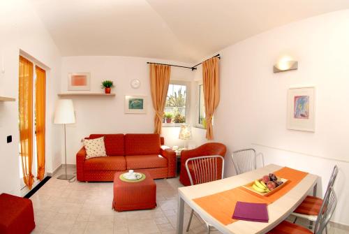 a living room with a red couch and a table at Residence Villa Beuca in Cogoleto