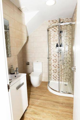 a bathroom with a toilet and a glass shower at Dúplex Costa de Fisterra I in Finisterre