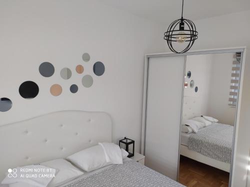 1 dormitorio con espejo junto a la cama en Deluxe apartment Jelena, en Trebinje