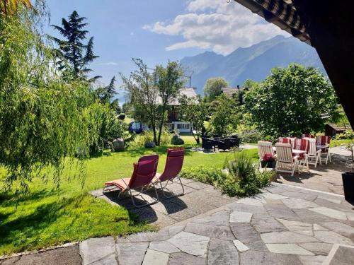a group of chairs in a yard with mountains in the background at B & B Brienz in Brienz