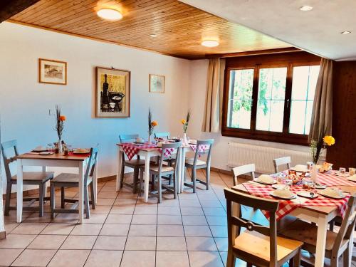 a dining room with tables and chairs and windows at B & B Brienz in Brienz