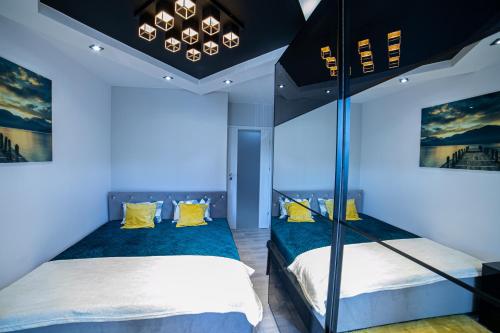 a bedroom with two bunk beds with blue lighting at Markiz Apartments in Toruń