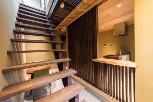 a winding staircase in a house with a kitchen at Umenotoan Gojyomibukawa in Kyoto