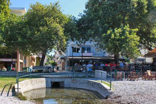 a bridge over a river with people sitting at tables at Vallia Suites - Luxury Penthouse in Nafpaktos