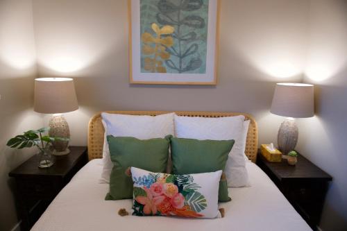 um quarto com uma cama com almofadas e 2 candeeiros em Port Renfrew Vacation Rentals em Port Renfrew