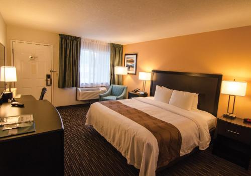 um quarto de hotel com uma cama grande e uma secretária em Cottage Grove Inn em Cottage Grove