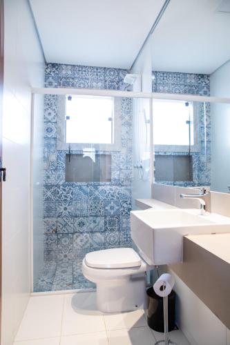 a bathroom with a toilet and a sink and a shower at ESPAÇO 250 - Apto mobiliado, 3 quartos, sendo uma suíte, banheiro social, cozinha completa, sala de estar, ar condicionado, tv e internet in Tiradentes