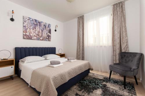 a bedroom with a bed and a chair at Apartment Antoni 2 in Podstrana