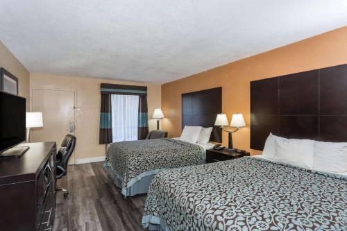 a hotel room with two beds and a flat screen tv at Days Inn by Wyndham Sarasota Bay in Sarasota