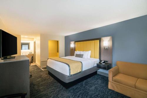 a hotel room with a bed and a couch at Baymont by Wyndham Franklin in Franklin