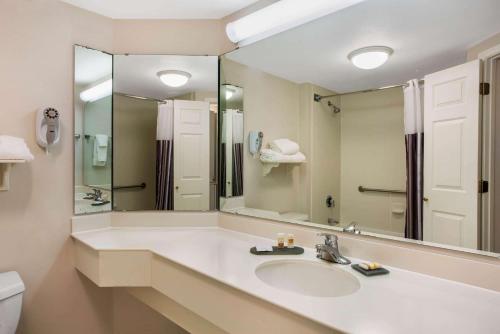 a bathroom with a sink and a large mirror at La Quinta by Wyndham Greensboro NC in Greensboro