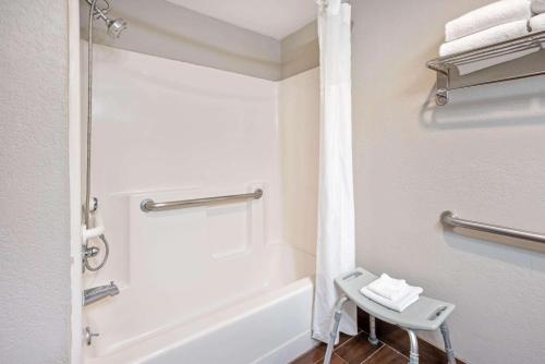 a bathroom with a bath tub and a chair in it at La Quinta Inn by Wyndham Caldwell in Caldwell