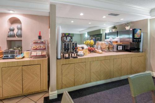 a restaurant with a counter with aasteryasteryasteryasteryasteryasteryasteryasteryastery at La Quinta Inn by Wyndham San Antonio Market Square in San Antonio