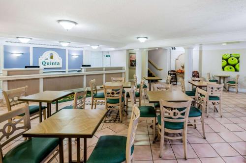 a restaurant with tables and chairs and a counter at La Quinta Inn by Wyndham Lufkin in Lufkin