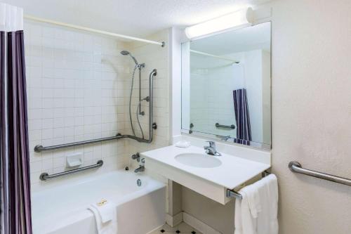 a bathroom with a sink and a tub and a mirror at La Quinta Inn by Wyndham Lufkin in Lufkin
