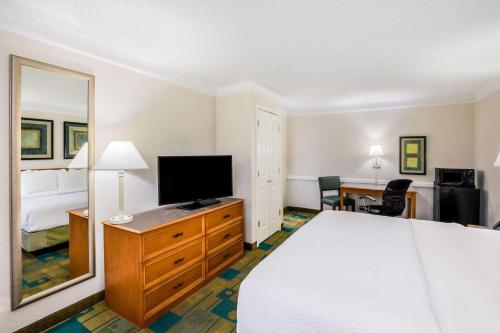 a hotel room with a bed and a flat screen tv at La Quinta Inn by Wyndham Lufkin in Lufkin