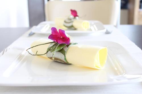 a white plate with a dessert with a flower on it at B&B Afrodite in Zonnebeke