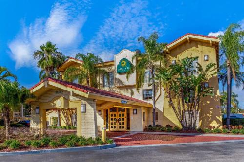 a building with palm trees in front of it at La Quinta Inn by Wyndham Tampa Bay Pinellas Park Clearwater in Pinellas Park