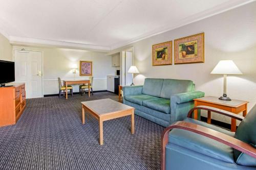 a living room with a couch and a table at La Quinta Inn by Wyndham Tampa Bay Pinellas Park Clearwater in Pinellas Park
