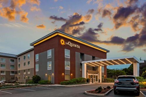 a hotel with a car parked in a parking lot at La Quinta by Wyndham San Francisco Airport North - Free Airport Shuttle in South San Francisco