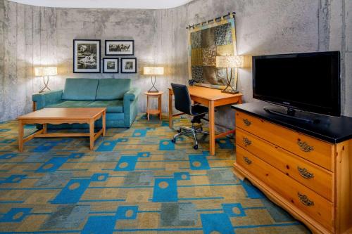 a living room with a tv and a couch and a table at La Quinta Inn & Suites by Wyndham Irvine Spectrum in Irvine