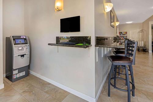a bar with a television and a bar stool in a room at The Hotel Oceanside in Oceanside