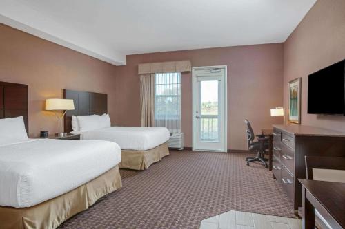 um quarto de hotel com duas camas e uma televisão em La Quinta by Wyndham Paso Robles em Paso Robles
