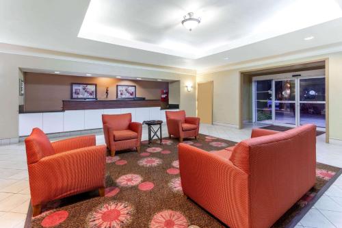 a lobby with orange chairs and a bar at La Quinta by Wyndham Seguin in Seguin