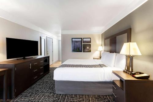 a hotel room with a bed and a flat screen tv at La Quinta by Wyndham Seguin in Seguin