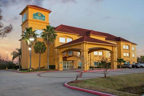 a yellow building with a clock tower in a parking lot at La Quinta by Wyndham Pearland in Pearland