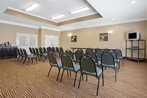 a conference room with chairs and a flat screen tv at La Quinta by Wyndham Pearland in Pearland