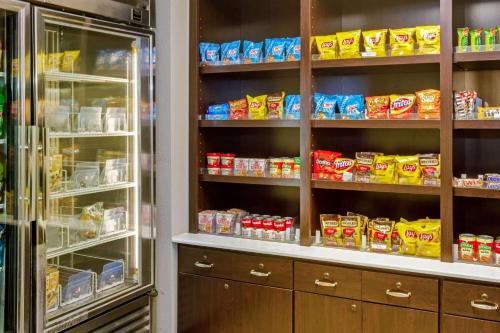 a kitchen with a refrigerator and shelves with food at La Quinta by Wyndham Birmingham Hoover in Hoover